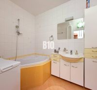 Spacious bathroom with shower and bathtub, 3-room apartment with light tiles.