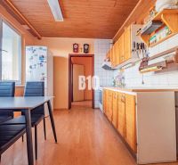 A kitchen in a 3-room apartment with a wooden decor floor and a dining table.