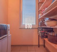Pantry in a 3-room apartment with shelves, kitchen appliances, and storage boxes.