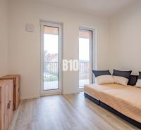 A room in a 3-room apartment with a sofa, cabinets, and a floor with a wooden decor.