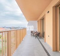 A balcony of a 3-room apartment in Nitra with a view of the city and outdoor seating.