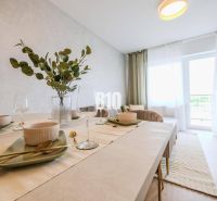 Dining table in a 2-room apartment with place settings and decor in light colors.
