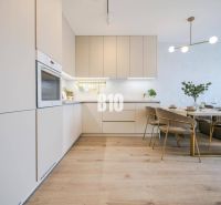 A bright kitchen with a dining table and a wooden decor floor in a two-room apartment.