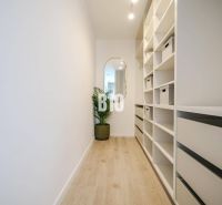 A hallway with shelves and a mirror, a floor with a wooden decor in a 2-room apartment.