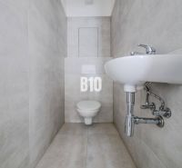 Bathroom with toilet and sink in a 3-room apartment, light tiles.