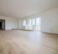 Spacious living room in a 3-room apartment with a wooden decor floor.