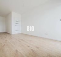 Spacious interior with wooden flooring and white walls in a 2-room apartment.