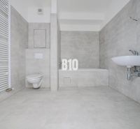 Bathroom with a bathtub, sink, and toilet in a new 2-room apartment.