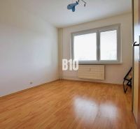 A room in a 3-room apartment with a wooden decor floor and a large window.