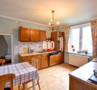 A kitchen in a family house with a wooden decor floor and wooden furniture.