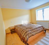 A bedroom with a double bed, wooden furniture, and a wooden decor floor in a family house.