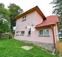 A family house in Makov with a pink facade, a garden, and a satellite dish on the wall.