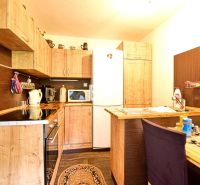 A kitchen in a cabin with wooden decor and rustic cabinets.
