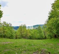 Green recreational plots with countryside views in Čadca surrounded by trees.