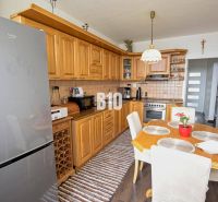 A kitchen in a 3-room apartment with a corner unit and a floor with a wood decor.