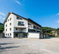 A building in Terchová with a clear sky and green hills in the background.