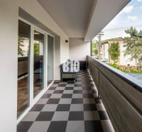 A balcony in a one-room apartment in Terchová with tiles, view of greenery and buildings.