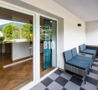 A balcony with rattan chairs in Terchová, overlooking a one-bedroom apartment.