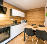 A kitchen with a wooden decor floor in a studio apartment.