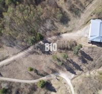 Aerial view of residential plots in Žilina surrounded by forest environment.