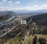 Aerial view of the surroundings of Žilina, residential plots, river, and forests.