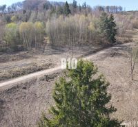 A sloped plot in Žilina for living with an access road and surrounded by forests.