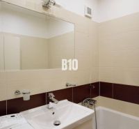 Bathroom with a shower and a sink in a 4-room apartment, cream tiles.