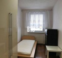 A simply furnished room with a single bed and a wooden-patterned floor in a 4-room apartment.