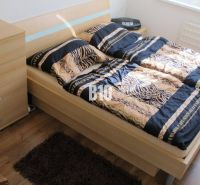 A bedroom with patterned bedding, a dresser, and a wooden decor floor in a 4-room apartment.