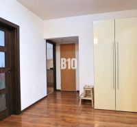 Interior of a 4-room apartment with a wooden decor floor, wardrobe, and mirror.