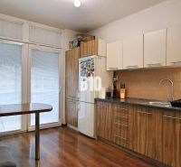 A kitchen in a 4-room apartment with a wood-patterned floor and a dining area.