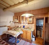 Interior of a family house with a kitchen, dining table, and wooden elements.