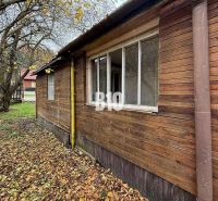 A family house in Kotešová with an older wooden facade, surrounded by autumn leaves and trees.