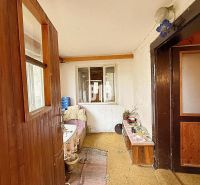 The interior of a family house with wooden paneling and simple furnishings.