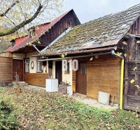 A family house in Kotešová with traditional architecture and autumn leaves in the yard.