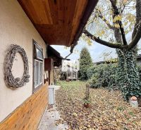 A family house in Kotešová with a garden covered with leaves and wooden wall cladding.