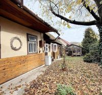 The exterior of a family house in Kotešová with autumn leaves in the yard.