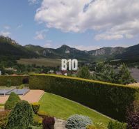 View from the villa in Súľov-Hradná of the hilly landscape and greenery in the garden.
