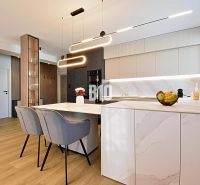 Stylish kitchen in a 3-room apartment with wood-patterned flooring and modern lighting.