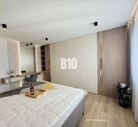 Bedroom in a 3-room apartment with wood-patterned flooring and a built-in wardrobe.