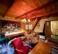 The interior of a cabin with a wooden ceiling, decorative carpet, and comfortable furniture.