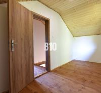 A room in a cottage with wooden doors and a wooden floor.