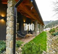 Covered terrace of the cottage in Horná Mariková with stone pillars and comfortable seating.