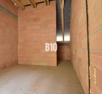 Unplastered bricks and an unfinished ceiling in a family house.