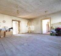 A messy room in a family house with a wooden floor and construction materials.