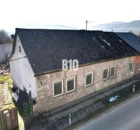 A family house in Bytča with a worn-out roof and plaster, next to the main road.