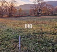 Sunset over green fields surrounded by trees and mountains, ideal for plots - housing.