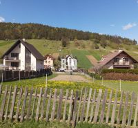 Lands - housing in Bytča with country houses, a fence, and green pastures in the background.