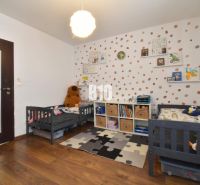 Children's room with cribs, decorative wall, and floor with wooden decor in a 3-room apartment.