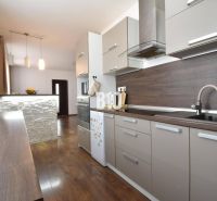 A kitchen in a 3-room apartment with a wooden decor countertop and flooring.